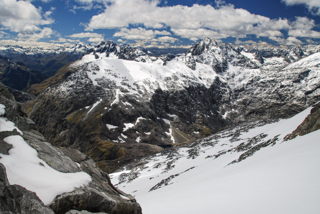Gertrude Saddle Route, My Favorite Trail to View the Breathtaking Fiordland Overlooking the yellow-green Gertrude Saddle and the gentle snowy ridge of Barrier Knob running toward rugged Barrier Peak.
