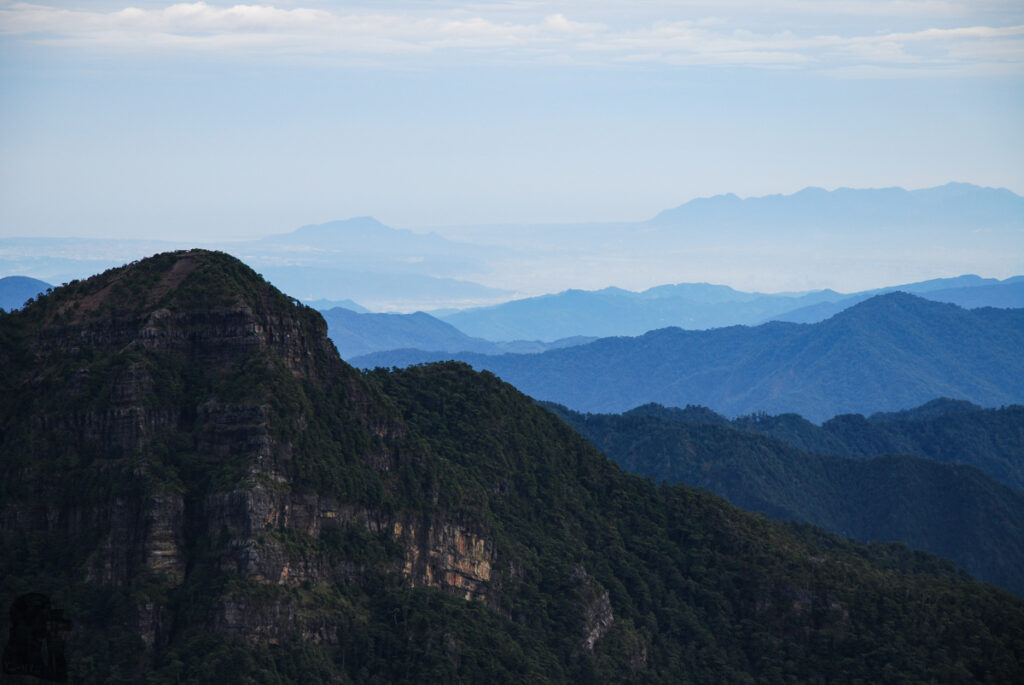The Holy Ridge, Shengleng "O" Trail (O聖), the Most Famous Ridgeline in Taiwan Looking toward the northern Taiwan with Taipei Basin flanked by Tatun Volcano Group (大屯火山群) and Guanyinshan (觀音山) in the distance. The Dongbajianshan (東霸尖山) is in the foreground.