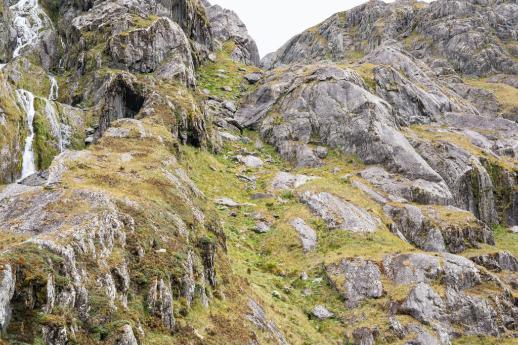 Valley of the Trolls / Lake Wilson, the Best Hidden Destination via Routeburn Track two hikers were walking down in the gully.