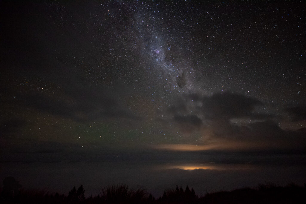 Mt. Fyffe, the Peak with the Bird's Eye View across Kaikōura Peninsula Milky Way and the Kaikōura’s light emitted through the cloud.