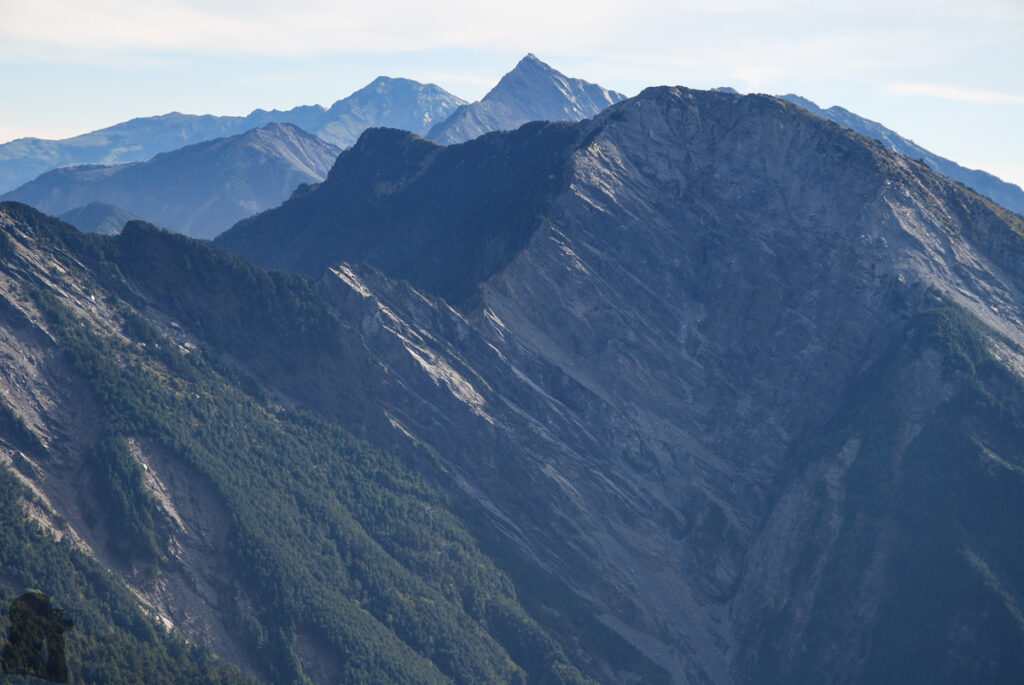 Mt. Bilu - Mt. Yangtou (畢祿羊頭), a Short Alpine Traverse above the Highway Wuming Cliff (無明斷崖), a characteristic of North Section 2; the sharp peak of Zhongyangjianshan (中央尖山) on North Section 1 stands behind it.